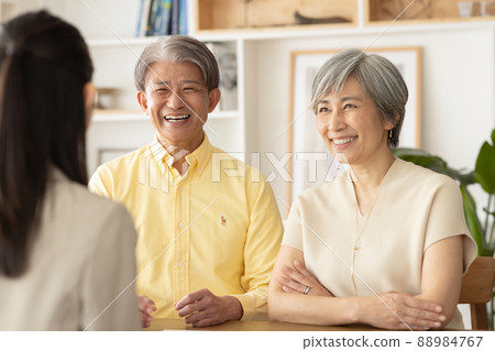 Middle-aged couple consulting with salesman 88984767