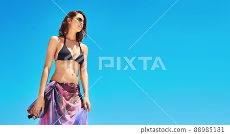Shes a summer stunner. Shot of a sexy young woman standing on the beach. Shes a summer stunner. Shot of a sexy young woman standing on the beach. 88985181