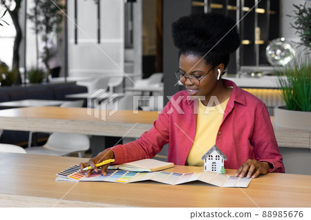 A millennial African American woman works or a student talks via video communication from a laptop or smartphone with friends or colleagues 88985676
