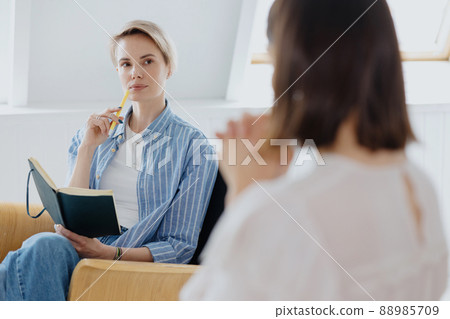 a young and beautiful European woman psychologist or psychiatrist with short blonde hair conducts therapy with a client a young and beautiful European woman psychologist or psychiatrist with short blonde hair conducts therapy with a client 88985709