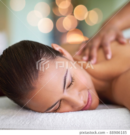 You are worth it. Shot of a young woman enjoying a back massage at a spa. 88986185