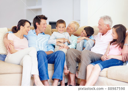 Three generations gather happily together. Three generations of family sitting together affectionately on the lounge couch. Three generations gather happily together. Three generations of family sitting together affectionately on the lounge couch. 88987598