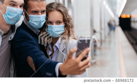 group of passengers in protective masks taking selfies in the subway. group of passengers in protective masks taking selfies in the subway. 88988172