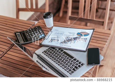top view.takeaway coffee, financial chart, and laptop on coffee table. top view.takeaway coffee, financial chart, and laptop on coffee table. 88988215