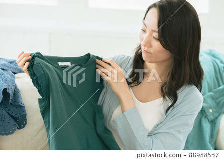 Young woman choosing clothes Young woman choosing clothes 88988537