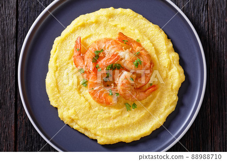 polenta with fried shrimps on plate, top view 88988710