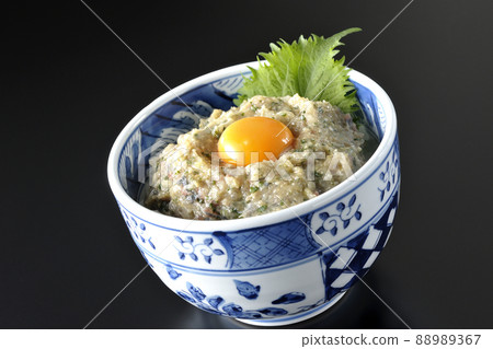 Photographed a horse mackerel namero bowl topped with egg yolk on a black background Photographed a horse mackerel namero bowl topped with egg yolk on a black background 88989367