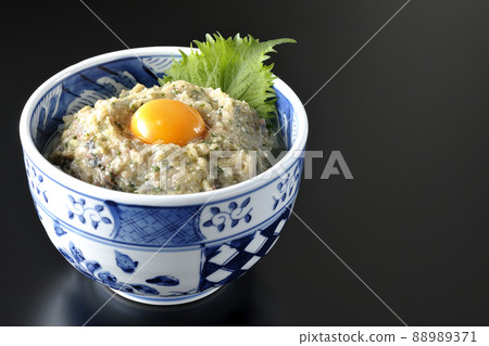 Photographed a horse mackerel namero bowl topped with egg yolk on a black background Photographed a horse mackerel namero bowl topped with egg yolk on a black background 88989371