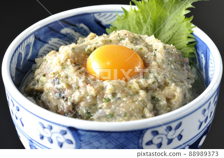 Photographed a horse mackerel namero bowl topped with egg yolk on a black background Photographed a horse mackerel namero bowl topped with egg yolk on a black background 88989373