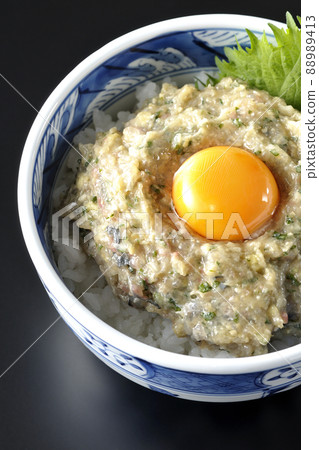 A bird's-eye view of a horse mackerel namero bowl topped with egg yolk on a black background A bird's-eye view of a horse mackerel namero bowl topped with egg yolk on a black background 88989413