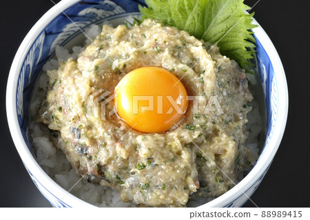 A bird's-eye view of a horse mackerel namero bowl topped with egg yolk on a black background A bird's-eye view of a horse mackerel namero bowl topped with egg yolk on a black background 88989415