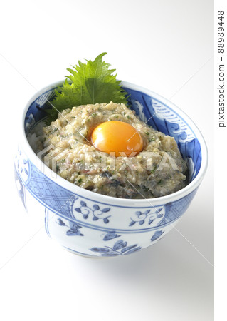 Photographed a horse mackerel namero bowl topped with egg yolk on a white background 88989448