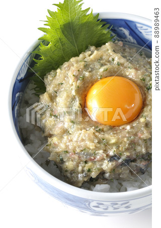 A bird's-eye view of a horse mackerel namero bowl topped with egg yolk on a white background 88989463