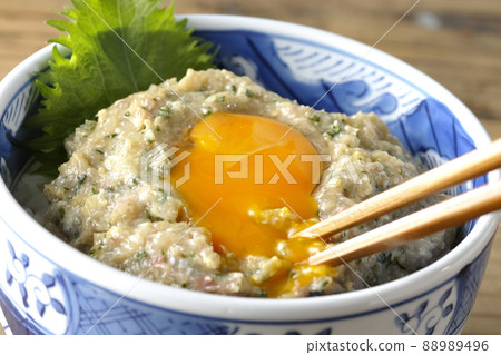 Eat egg yolk topped with horse mackerel namero bowl with chopsticks Eat egg yolk topped with horse mackerel namero bowl with chopsticks 88989496