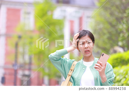 一個表情不安的女人拿著智能手機,抱著頭 1 一個表情不安的女人拿著智能手機,抱著頭 1 88994238