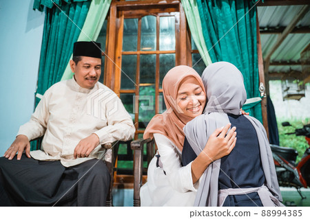 muslim daughter kneel and shake their parent's hand asking for forgiveness muslim daughter kneel and shake their parent's hand asking for forgiveness 88994385