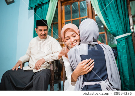 muslim daughter kneel and shake their parent's hand asking for forgiveness 88994386
