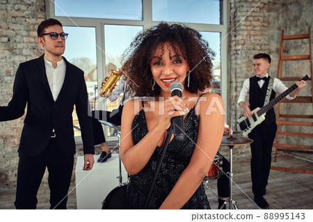 Repetition of multi ethnic jazz band in loft. Bass guitar player, electric guitar player, saxophonist and drummer at loft. Jazz music and jam session concept. passion for music and youth culture Repetition of multi ethnic jazz band in loft. Bass guitar player, electric guitar player, saxophonist and drummer at loft. Jazz music and jam session concept. passion for music and youth culture 88995143