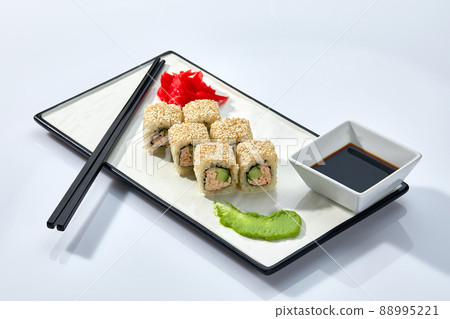 California or Philadelphia sushi rolls set served on a white tray over white background. Japanese cuisine concept, traditional recipe. California or Philadelphia sushi rolls set served on a white tray over white background. Japanese cuisine concept, traditional recipe. 88995221
