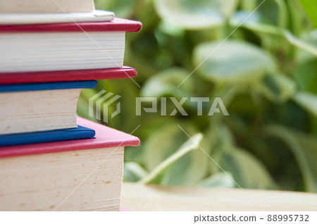 Stack of books with blurred nature background. Copy space concept 88995732