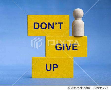 Don't give up text on wooden blocks with wooden doll standing at the edge. Motivational concept 88995773