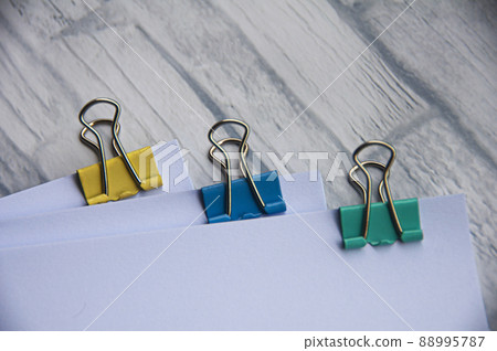 Blank white paper with clip binders on white wooden table. Copy space concept Blank white paper with clip binders on white wooden table. Copy space concept 88995787