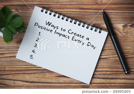 Top view of text - Ways to create a positive impact every day. With pen and plant on wooden table. Lifestyle concept Top view of text - Ways to create a positive impact every day. With pen and plant on wooden table. Lifestyle concept 88995805