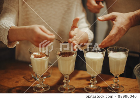 Family cooking homemade eggnog by the Christmas tree having fun Family cooking homemade eggnog by the Christmas tree having fun 88996046