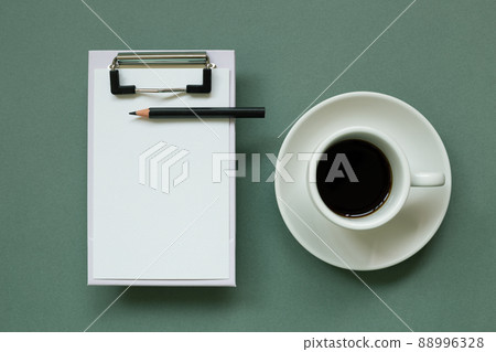 Clipboard and paper sheet with cup of coffee on green background. top view, copy space 88996328