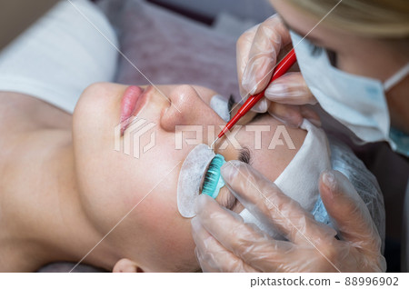 The master uses a multifunctional tool for laminating eyelashes. 88996902