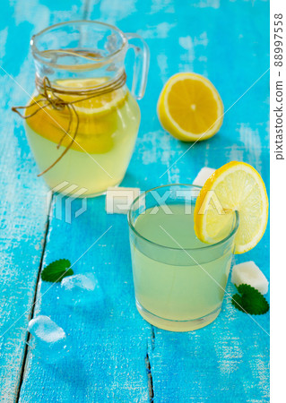 A drink with fresh lemon on a wooden table A drink with fresh lemon on a wooden table 88997558
