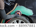 Hands of a painter who grinds a car for painting in a mechanical workshop. 88997881