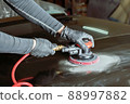 Grinding body parts with a pneumatic grinder before painting. 88997882