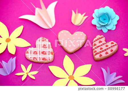 Paper art, bright handmade summer holiday flowers, craft on a pink background with cookies in the form of hearts. Colorful greeting card for Mom's day, Easter, Valentine's Day 88998177
