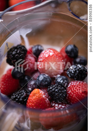 pouring milk into the blender for berry smoothie pouring milk into the blender for berry smoothie 88998386