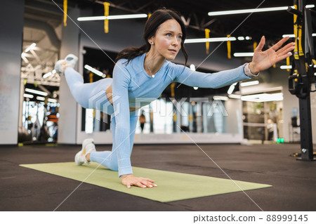 Fitness woman doing gymnastics. Sunbird yoga pose. Pilates posture Fitness woman doing gymnastics. Sunbird yoga pose. Pilates posture 88999145