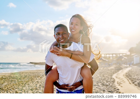 Happy young beautiful couple having fun on the beach. Happy young beautiful couple having fun on the beach. 88999746