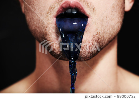 The colour of lies. Closeup of a young mans mouth spitting out purple liquid. The colour of lies. Closeup of a young mans mouth spitting out purple liquid. 89000752