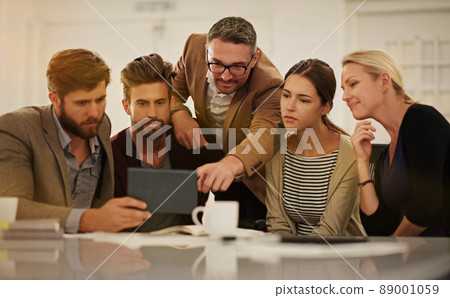 Whats that. Cropped shot of a group of businesspeople looking at a tablet in the boardroom. Whats that. Cropped shot of a group of businesspeople looking at a tablet in the boardroom. 89001059
