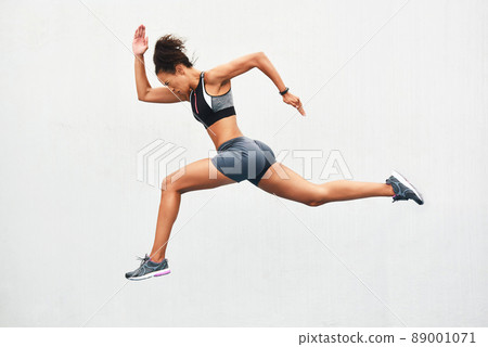 Giving it all shes got. Full length shot of an attractive young female athlete running along the track. Giving it all shes got. Full length shot of an attractive young female athlete running along the track. 89001071
