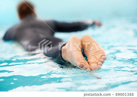 Your wave is waiting for you. Rearview shot of a man surfing in clear blue water. 89001388