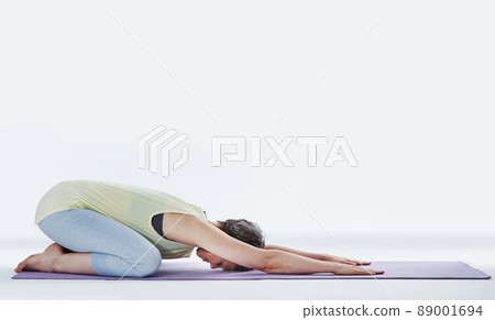 Make sure you warmup before exercising. Full length shot of an attractive woman stretching before yoga. 89001694