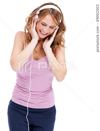 Mesmerized by the music. Studio shot of a young woman listening to music through her headphones. Mesmerized by the music. Studio shot of a young woman listening to music through her headphones. 89002003