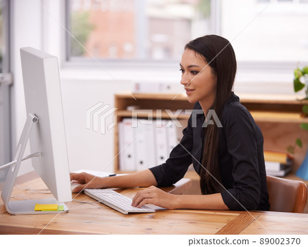 Living in a corporate world. Shot of a young businesswoman in her office. 89002370