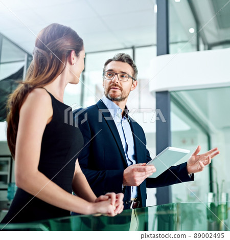What do you think. Cropped shot of two businesspeople talking in the office. What do you think. Cropped shot of two businesspeople talking in the office. 89002495