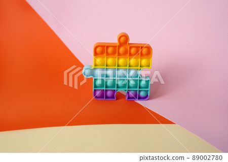 New popular silicone colorful anti-stress popit toy for baby on the background with geometric shapes. New popular silicone colorful anti-stress popit toy for baby on the background with geometric shapes. 89002780