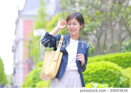 Business woman looking at the camera while supporting the glasses with her right hand 1 89003636