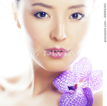 young pretty asian woman with flower purple orchid closeup isolated on white background spa smiling casual young pretty asian woman with flower purple orchid closeup isolated on white background spa smiling casual 89004264