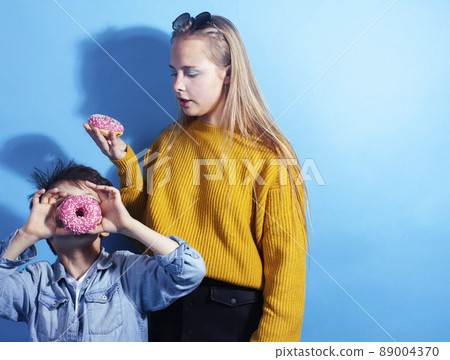 happy family brother and sister eating donuts on blue background, lifestyle people concept, boy and girl eating unhealthy food happy family brother and sister eating donuts on blue background, lifestyle people concept, boy and girl eating unhealthy food 89004370