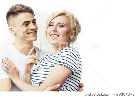 young pretty teenage couple, hipster guy with his girlfriend happy smiling and hugging isolated on white background, lifestyle people concept young pretty teenage couple, hipster guy with his girlfriend happy smiling and hugging isolated on white background, lifestyle people concept 89004372